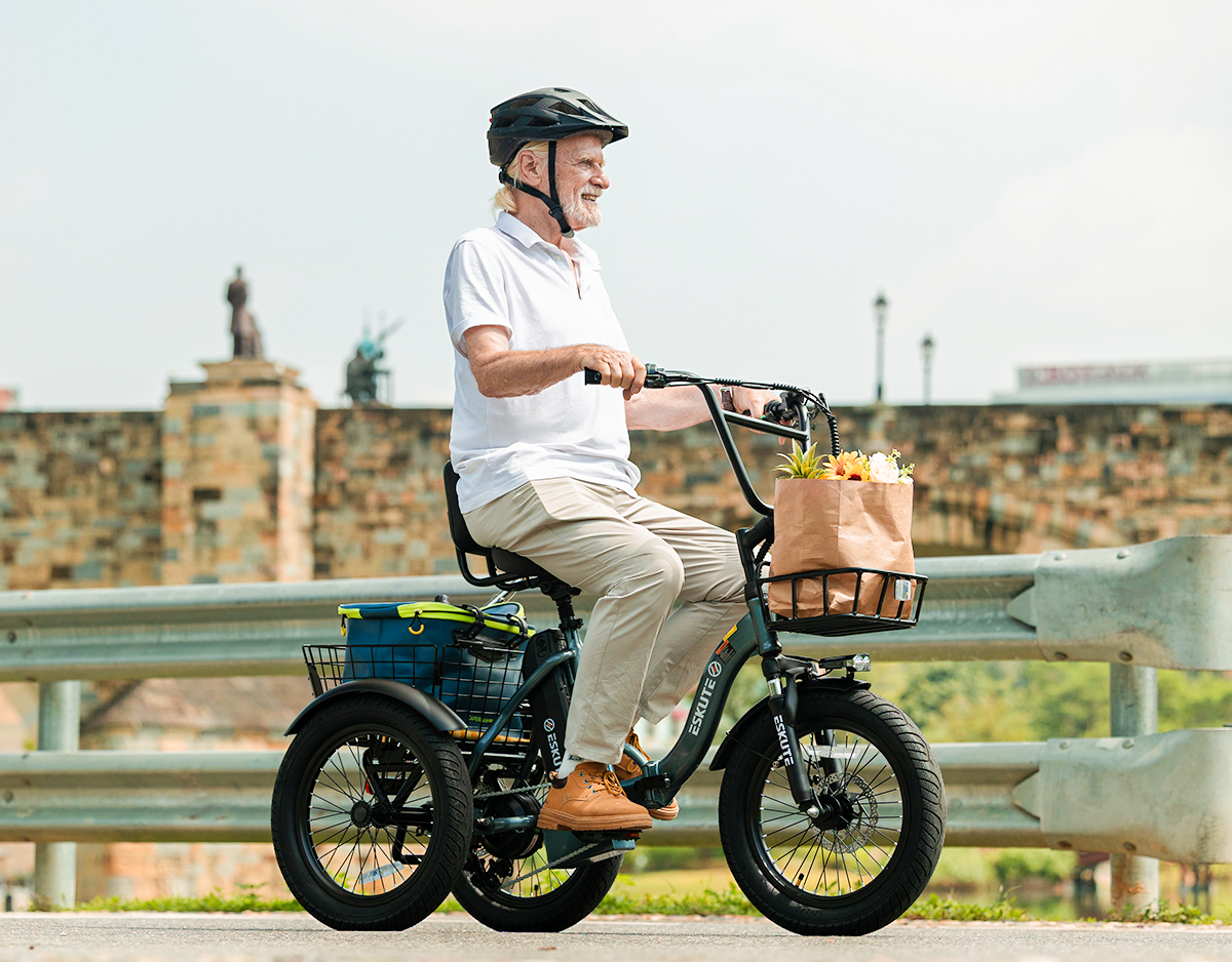 Man riding a tricycle with a basket on a road