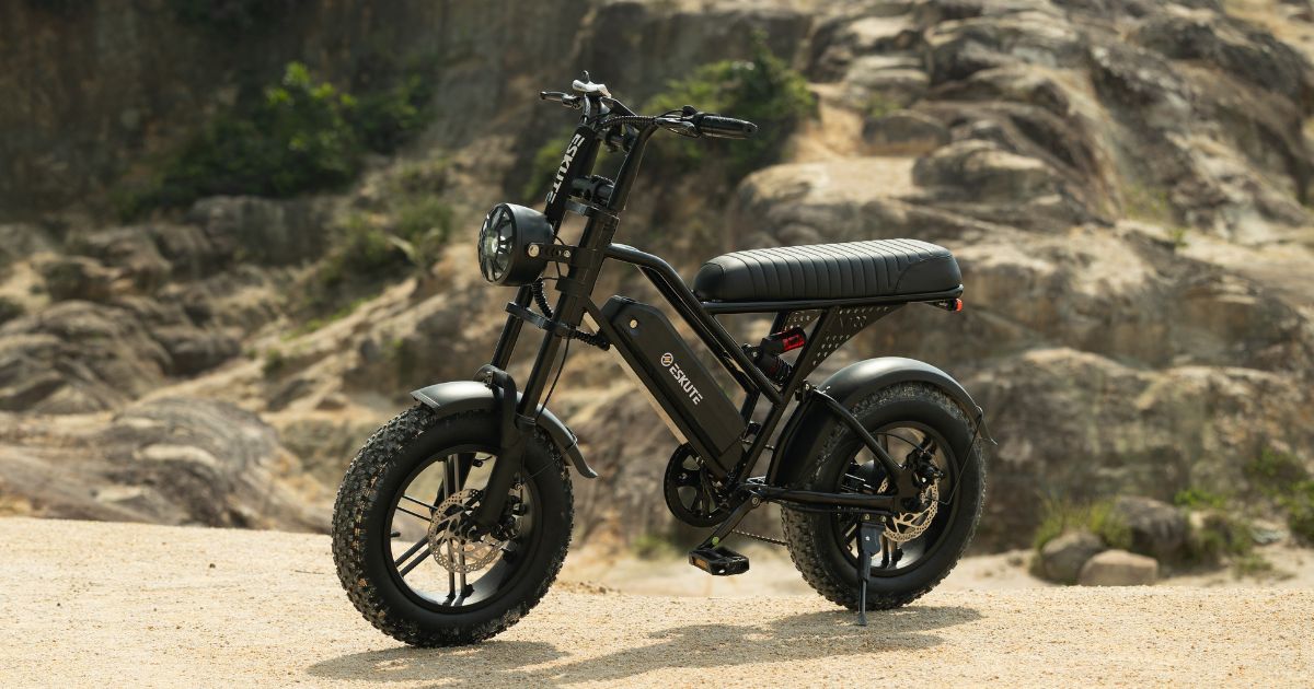 the Eskute V100 electric bike for teens, featuring 16-inch fat tires, a long seat, and an integrated frame-mounted battery, parked on a rocky trail with a focus on its high-torque motor and stability features